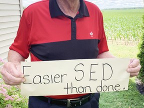 Appropriately enough, Mitchell's Harry Norris will have walked the equivalent of across Canada on July 1 since the COVID-19 pandemic began in mid-March 2020, or 475 consecutive days. He's holding a sign he received 25 years ago that has special meaning: Easier SED than done, the SED referring to Stress, Exercise and Diet, but now he refers to it more simply: Steps Every Day. ANDY BADER/MITCHELL ADVOCATE