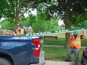 Larry Gill, left, Owen Sound's parks and cemetery supervisor, and Adam Parsons, the city's manager of parks and open space, load the wooden Ryerson Park sign into the back of a city pickup truck in June 2021. DENIS LANGLOIS
