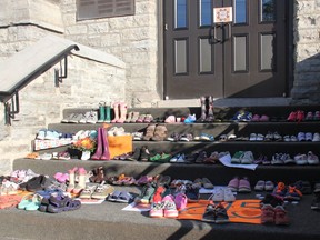Approximately 200 childrens' shoes, boots and moccasins were placed on the steps of St. Columbkille's Cathedral in Pembroke Monday evening as a memorial to the 215 children whose remains were discovered on the grounds of a residential school in Kamloops, B.C.