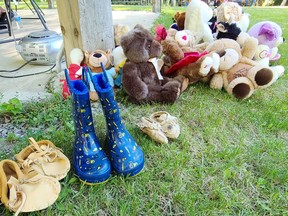 Those who attended the ceremony at Pikwakanagan May 31 to honour the 215 children found in an unmarked grave at a former residential school site in British Columbia left shoes and stuffed animals near the arbour in the centre of the Pikwakanagan cultural grounds.