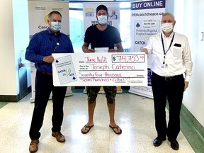 Joseph Caterino is smiling under that mask as he collects a cheque for nearly $75,000 after catching the Ace of Spades in Week 17 of the Pembroke Regional Hospital Foundation's fundraising lottery. He received the winnings from PRH President and CEO Pierre Noel and PRH Foundation executive director Roger Martin (right). The lottery helped to raise approximately $117,000 for the hospital's Cancer Care Campaign.