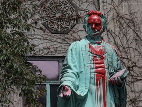 Red paint covers the defaced Ryerson University statue of Egerton Ryerson, considered an architect of Canada's residential indigenous school system, following the discovery of the remains of 215 children on the site of British Columbia's former Kamloops Indian Residential School, in Toronto, Ontario, Canada June 2, 2021.  REUTERS/Chris Helgren ORG XMIT: PPP-TOR503