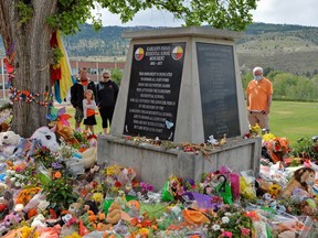 FILE PHOTO: People visit a makeshift memorial on the grounds of the former Kamloops Indian Residential School, after the Tk'emlups te Secwepemc band council encouraged mourners to take part in a national day of prayer to honour the remains of 215 children that were found at the site in Kamloops, British Columbia, Canada June 6, 2021.  REUTERS/Jennifer Gauthier//File Photo