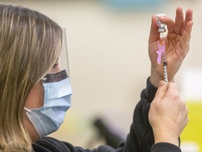 A public health nurse loads a syringe with the Pfizer COVID-19 vaccine at the Caradoc community centre earlier this year. Mike Hensen/Postmedia Network