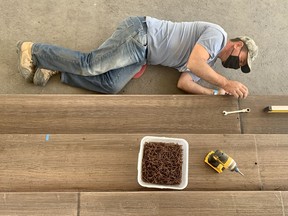 Stratford Festival scenic carpenter Jody Satchell works on the stage Thursday afternoon under the canopy adjacent to the Tom Patterson Theatre.