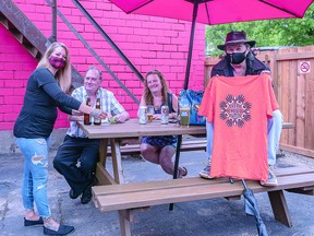 On hand for the opening of the outdoor patio bar at Reggie's Downtown were co-owner Kylie Lapossie and customers Ivan Jubenville, Donna Jubenville and "Fonzi." BOB DAVIES/SAULT THIS WEEK