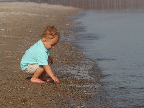 Oaklen Fernandes, 1, plays in the water at Canatara Park Beach in Sarnia Wednesday during a visit with his family. Lambton Public Health has begun its summer water quality monitoring at public beaches in the region.