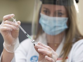 Pharmacist Alison Davison prepares a dose of Pfizer-BioNTech COVID-19 vaccine at Shoppers Drug Mart pharmacy on 17 Ave. S.W. in Calgary on Friday, March 5, 2021. Two all-inclusive seven-day trips for two to Mexico are among travel prizes for Albertans who receive two doses of an approved COVID-19 vaccine.