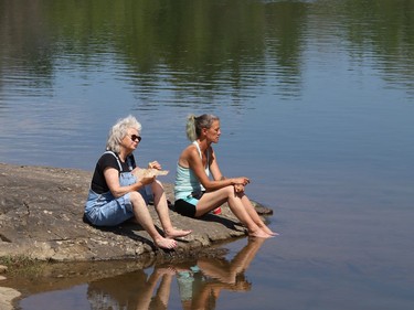 Line Roseborough, left, and Tanya Whitford take in the scenery at the pond at the Delki Dozzi track on Monday.