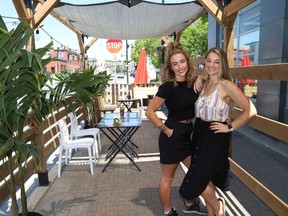 Valerie Fremlin, left, and Kelsey Cutinello, co-owners of La Fromagerie on Elgin Street, prepare their patio for opening on Friday. The Ford government announced on Monday that Ontario will move into Step One of its reopening plan on Friday at 12:01 a.m., three days ahead of schedule. Step One includes allowing non-essential retail stores to reopen, and bars and restaurants to begin serving customers on their patios.