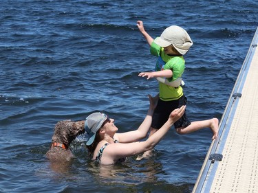 Jay (Jess) Ryan and her nephew, Oscar Ryan, 4, and Peat the dog play in the water at Ramsey Lake on Wednesday.