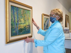 Jane Cameron, of Sudbury Paint and Custom Framing in Sudbury, Ont., prepares an exhibition of artwork by the late Bruno Cavallo at Gallery 174. John Lappa/Sudbury Star/Postmedia Network