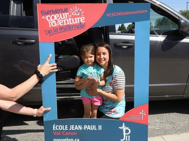 Christine Dubreuil and her daughter, Mikelle, 4, visit Ecole Jean-Paul II in Val Caron, Ont. at a drive-through welcome for incoming kindergarten students on Thursday. The event was held to welcome children who are starting kindergarten in September 2021.