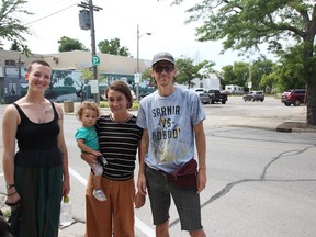 Elise McDonald (left) stands with Michelle and Josh Walters and their daughter Maggie, who is one, near the municipal parking lot where a Mitton Village Block Party was being held in August, 2019. The parking lot is being transformed with city funding through a new community improvement plan program. Tyler Kula/Postmedia Network