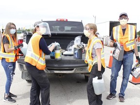 Volunteer Jenna Secord, on left, with City of Timmins' Environmental Co-ordinator Christina Beaton, with two other volunteers Keelin Levasseur and George Lajeunesse, are seen taking out some of the household waste items from the bed of pickup truck during the annual Household Hazardous and Special Waste Day event held at the Archie Dillon Sportsplex on Saturday. 

RICHA BHOSALE/The Daily Press