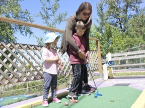 Erin Millette was giving some golfing lessons to her children Xavier, 5, and Sienna,3, at the Miniputt and Batting Cages at Hollinger Park on Tuesday afternoon. The family recreational facility recently opened forthe season and operates from 10 a.m. to 10 p.m. throughout the week.

RICHA BHOSALE/The Daily Press