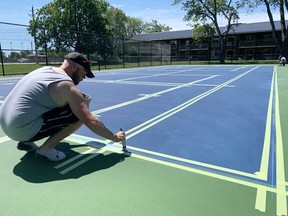 Rick Abbiss (left) and Matt Pearson, of New Court Sport Solutions, of Hamilton, painted the new West Perth tennis and pickleball courts last week, including the lines June 16. The finishing touches allows for the respective sports to be played now after a winter and COVID-related delay. The two colours applied, U.S. Open blue and a light green, along with white and grey lines look sharp. West Perth Facilities Manager Darcey Cook said people can register for lessons this week. ANDY BADER/MITCHELL ADVOCATE