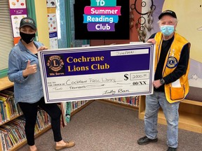 Findlay Barr (right) of the Cochrane Lions Club presents Cochrane Library CEO Christina Blazecka a cheque for $2000 for the TD Summer Reading Club.TP.jpg