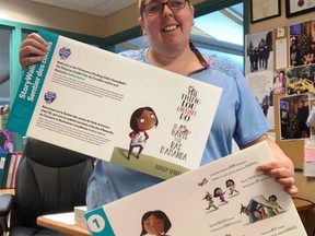 Ardis Chedore, Assistant to the CEO and Library Archivist shows off some of the story panels that will placed on the boardwalk for summer reading. .TP.jpg