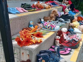 Tokens of remembrance cover the steps of St. Thomas Anglican Church, left Monday during a march memorializing Indigenous children lost to Canada's residential school system. The basket of strawberries disappeared that night from the inner city location.Eric Bunnell