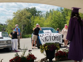 Victoria Jenner poses for pictures from her family during Beaver Brae Secondary School's drive-thru graduation ceremony on Thursday, June 24.