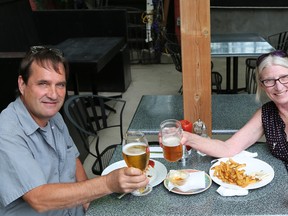 Craig and Laurie McEwan didn't let a quick burst of rain spoil their first lunch on a patio in over two months Friday at Jazzmyn's in Owen Sound. Greg Cowan/The Sun Times