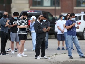 People line up to enter a vaccine clinic ,on Higgins Avenue, in Winnipeg on Friday, June 18, 2021.