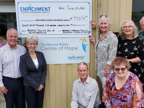 Members of the Rollins family gather with Enrichment Centre staff to announce the donation of more than $77,000 from the Maurice Rollins Day of Remembrance in Support of Mental Health. Second from background right is the centre's executive director, Sandie Sidsworth.