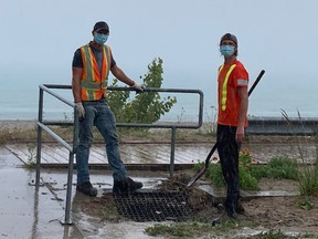 Municipal Employees, Mark Stopford and Owen Musselman, worked quickly to clear a plugged storm sewer in a rain storm. Glenn Hedley photo