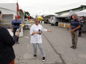Chamber of Commerce chief executive officer Jill Raycroft, centre, promotes Curbside Culture at the former fairground Friday in Belleville. Streaming the event live to Facebook was the chamber's Anna Fraiberg, left, as Mayor Mitch Panciuk and chamber chair Peter Kempenaar looked on.