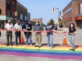 Chrislynn Losier, from left, Timmins-James Bay MP Charlie Angus, Timmins Mayor George Pirie, Matthieu Villeneuve, who is with Fierté Timmins Pride group, Timmins MPP Gillies Bisson, Downtown Timmins: BIA president Jamie Roach and Nadia Piccotti, strategic plan/projects intern with the BIA, celebrate the new Pride crosswalk on Third Avenue at the Pine Street South intersection on Monday. RICHA BHOSALE/THE DAILY PRESS
