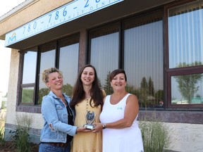 Karry Manegre, left, and Mayor Janet Jabush, right, presented the first-place trophy for the Mayerthorpe sign war to Eve Kazachenko, Mayerthorpe Family Dental owner. The awards recognized participants’ efforts and “punnyness.”