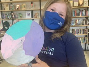 Tegan Pigeon poses with her latest artwork Tuesday at OutLoud. OutLoud was nominated by Sarah Gervais in the Telus #friendlyfuturedays contest. The not-for-profit will receive $10,000.