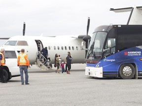 Pikangikum First Nation evacuees began arriving at Timmins Victor M. Power Municipal Airport Wednesday afternoon after being forced to flee their Northwestern Ontario community due to forest fires raging in that part of the province. After getting off the plane, the residents began boarding buses to be transported to Ramada Inn. RICHA BHOSALE/THE DAIILY PRESS