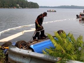 Larry Bartlett prepares to hook a second cable to the underside of a Subaru that went into Trout Lake Monday morning and was pulled out mid-afternoon.
PJ Wilson/The Nugget