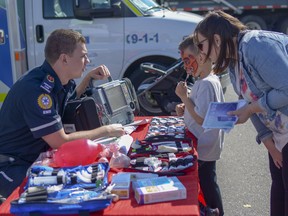 Paramedic Chris Wyshynski shows seven-year-old Drake and his mother Nicole some of the equipment used by EMS on Sat., Sept. 8, 2018. This was the first year that Thank You Day for First Responders was held in conjunction with airdrieFEST.