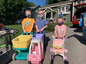 Oliver, William and Gwen Gerscht were in the market for some new wheels as they strolled from house to house for the townwide yard sale on Saturday, July 10. Hannah MacLeod/Lucknow Sentinel