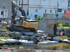 Work crews have removed large stone blocks from the east bank of the Moira River to access the foundation of the city footbridge which is set for demolition as part of a $2.9 million replacement project by the City of Belleville. DEREK BALDWIN