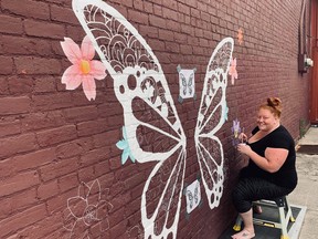 Emily Strachan works on the second interactive mural in Huron-Kinloss, which is located on the side of Everlasting's Flowers and Gifts. Cheryl Wallis photo