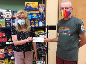 On Thursday, July 22, Kincardine Pride board member Dave Trumble (R) donated $500 to the Saugeen First Nation Covid Relief fund. Receiving the cheque is Cathy Banks at the food and donation receiving area at the Band office. SUBMITTED