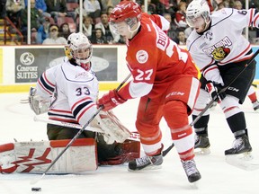 Soo Greyhound Michael Bunting works for control of the puck in front of Owen Sound Attack goaltender Brandon Hope as Attack defenceman Brayden Rose  looks on during first-period action Friday, March 21, 2014 at the Essar Centre in Sault Ste. Marie, Ont. JEFFREY OUGLER/SAULT STAR/QMI AGENCY