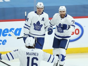 Toronto Maple Leafs centre Auston Matthews (left) celebrates his goal against the Winnipeg Jets with Nick Foligno (right) and Mitch Marner in Winnipeg on Thurs., April 22, 2021.