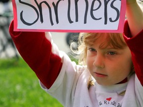 Truly grateful: Six-year-old Emily Shrubsall of London holds up a thank you sign at the Shriners parade in London yesterday. The youngster receives treatment at Montreal’s Shriners Hospital.