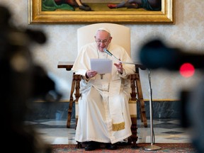 This photo taken and handout on March 03, 2021 by The Vatican Media shows Pope Francis holding a live streamed weekly private general audience in the the library of the apostolic palace at The Vatican. (Photo by Handout / VATICAN MEDIA / AFP)