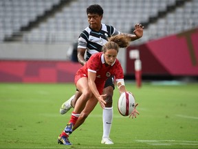 Canada's Breanne Nicholas of Blenheim, Ont., reaches for the ball in front of Fiji's Rusila Nagasau in a women’s rugby sevens preliminary-round game at Tokyo Stadium during the Tokyo Olympics on July 29, 2021. (Photo by Greg Baker/AFP via Getty Images)