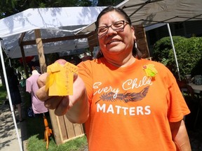 Lana Parenteau, Chatham-Kent's Indigenous peer navigator, shows an example of the orange pins being made to raise donations for local Indigenous organizations. She was at Discover Art Blenheim in Blenheim, Ont., on Saturday, July 17, 2021. Mark Malone/Chatham Daily News/Postmedia Network