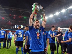 Soccer Football - Euro 2020 - Final - Italy v England - Wembley Stadium, London, Britain - July 11, 2021 Italy's Domenico Berardi celebrate with the trophy after winning Euro 2020 with teammates Pool via REUTERS/Andy Rain