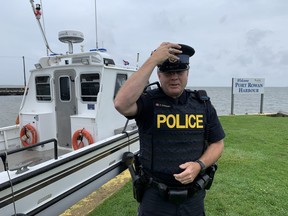 Acting Sgt. Ed Sanchuk held onto his hat Sunday at the Port Rowan marina where a large police presence had prepared to deal with hundreds of partying boaters at the annual party held at Pottahawk Point.