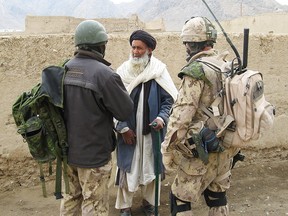 Warrant Officer Chuck Graham questions an Afghan elder about Taliban activity in the Panjwaii district, Afghanistan, through an Afghan interpreter Tuesday March 20, 2007.