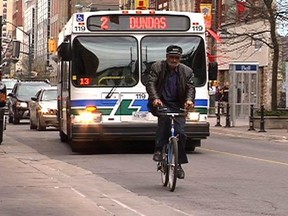 A cyclist rides in front of a London Transit bus in this LFP file photo.